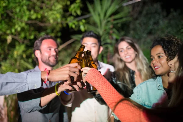 Genç erkekler ve kadınlar partide bira içiyorlar.