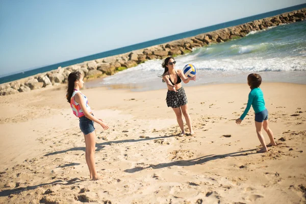 Kız kardeşler ve erkek kardeşler sahilde oynuyorlar. — Stok fotoğraf