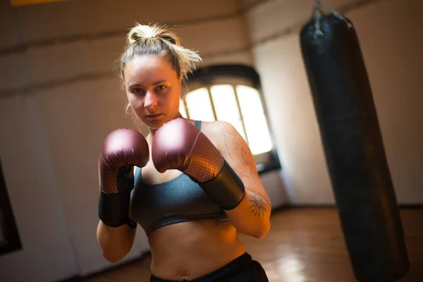 Serious sportswoman in boxing gloves