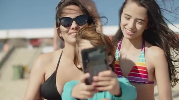 Vista frontale del bambino che prende selfie con la famiglia sulla spiaggia — Video Stock