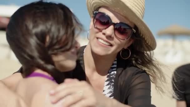 Madre feliz en gafas de sol aplicando loción protector solar a la hija — Vídeos de Stock