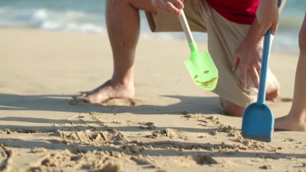 Movimiento lento de papá soltero y el hijo dibujo en arena mojada en la playa — Vídeos de Stock