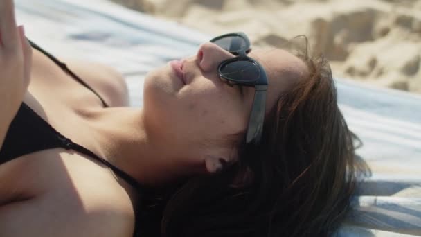 Close-up tiro de meninas rosto deitado e lendo livro na costa do mar — Vídeo de Stock