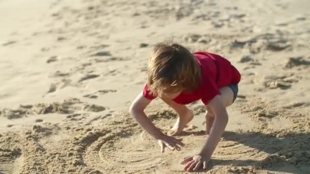 一个小男孩在沙滩上和父亲一起在沙滩上画的长长的镜头 — 图库视频影像