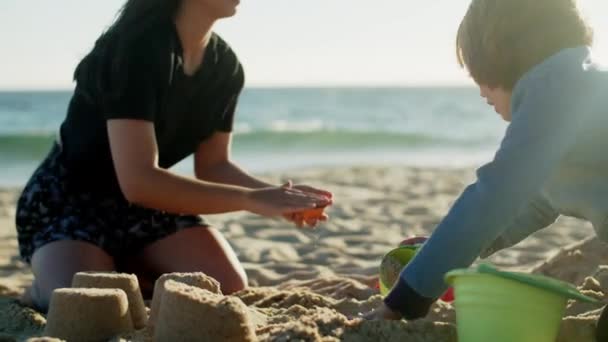 Slider shot de niños jugando con arena en un día soleado en la playa — Vídeos de Stock
