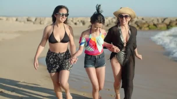 Tampilan depan ibu bahagia berjalan dengan anak perempuan di sepanjang pantai — Stok Video