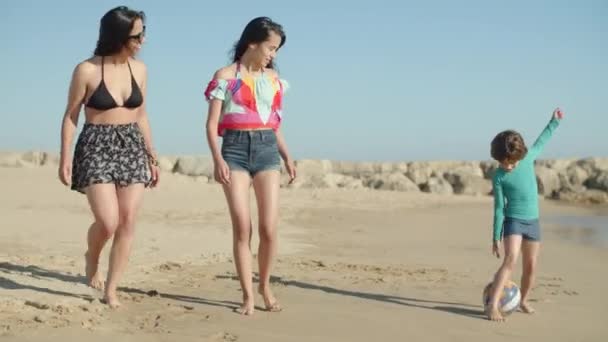 Vista frontale dei bambini adolescenti felici che corrono con la palla sulla spiaggia — Video Stock