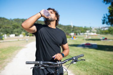 Sportif kıvırcık adam antrenmandan sonra dinleniyor.