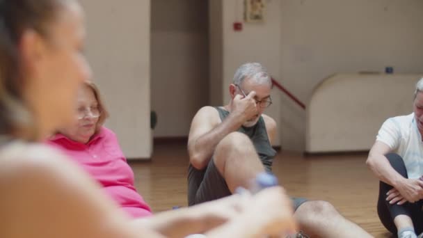 トレーニングの後、サークルで床に座っている高齢者 — ストック動画