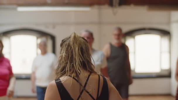 女性舞踊教師の集団への移動を示すバックビュー — ストック動画