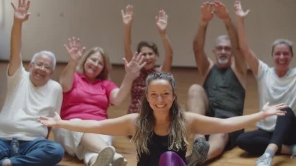 Учительница сидела на полу с танцевальной группой пенсионеров — стоковое видео