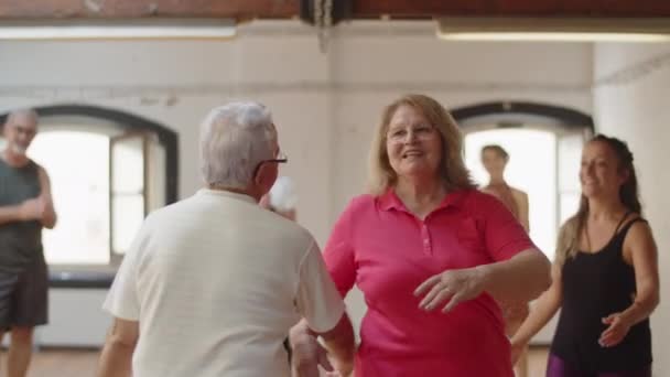 Mittlere Aufnahme eines älteren Paares, das mit einem Lehrer einen Tanz einübt — Stockvideo