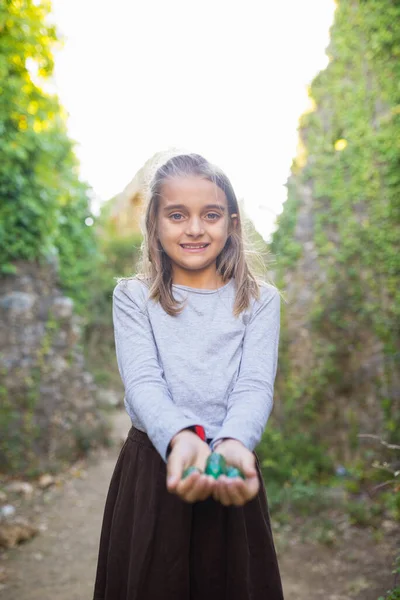 Cute little girl gra z kulkami marmuru — Zdjęcie stockowe