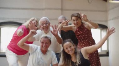 Kıdemli dansçılardan oluşan bir takım stüdyoda baş parmaklarını kaldırıyor.