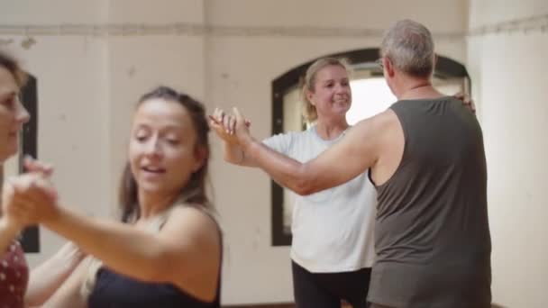 Medium shot of senior couples dancing together in studio — Stock Video