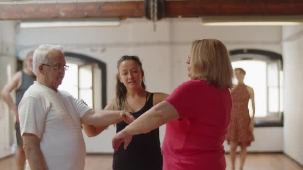 Vista frontal del profesor de danza enseñando a la pareja mayor a moverse — Vídeos de Stock
