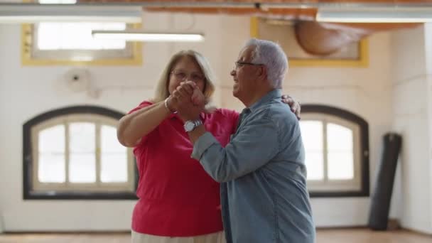 Mittlere Aufnahme eines glücklichen Senioren-Paares, das gemeinsam im Ballsaal tanzt — Stockvideo