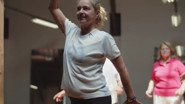 Střední záběr šťastné choreografie ukazující pohyby v tanečním sále — Stock video