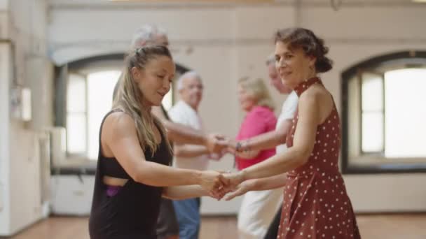 Vista lateral de parejas tomando clases de baile en el salón de baile — Vídeos de Stock