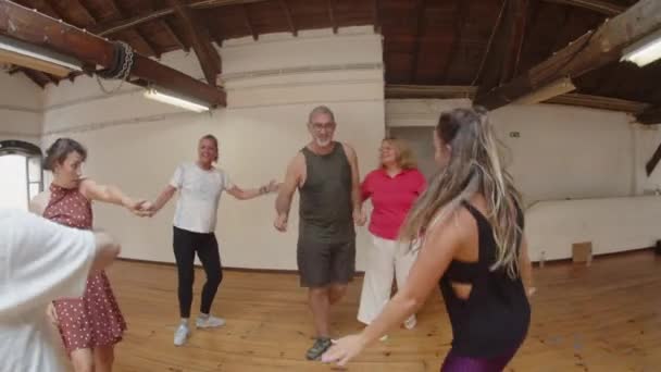 Lange kans van gelukkige ouderen dansen in ronde met leraar — Stockvideo