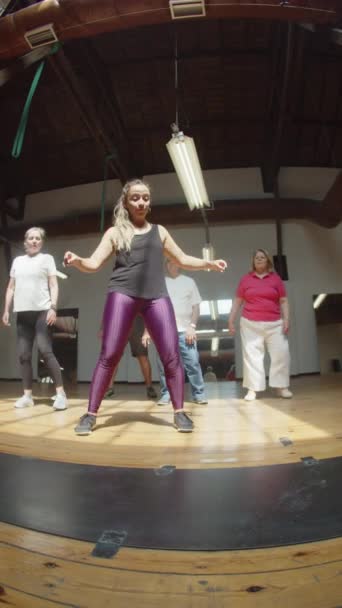 Νεαρός δάσκαλος που δείχνει χορευτικές κινήσεις σε ηλικιωμένους στο στούντιο — Αρχείο Βίντεο