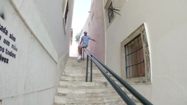 Slider shot szczęśliwego człowieka ślizgającego się po balustradzie na ulicy — Wideo stockowe