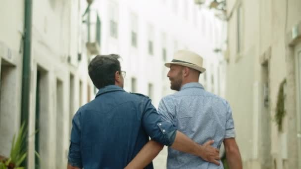 Powrót widok szczęśliwy facet para chodzenie w dół pasa i przytulanie — Wideo stockowe