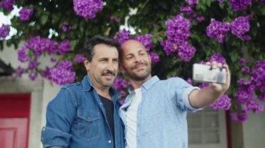 Ön manzara mutlu eşcinsel çift sokakta selfie çekiyor.