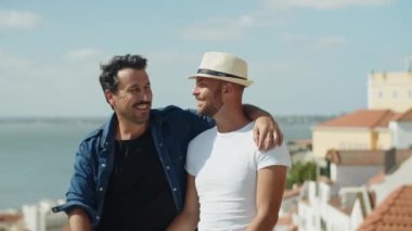 Mutlu homoseksüel adam oturuyor ve aşıkların omzuna sarılıyor.