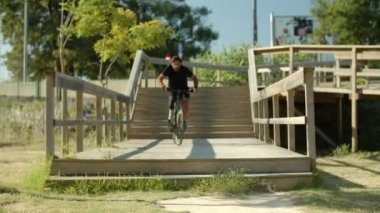 Parkta biyonik bacaklı bisikletli odaklanmış bir adamın ön görüntüsü.