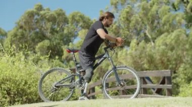 Cep telefonu kullanan engelli motorcunun yan görünümü