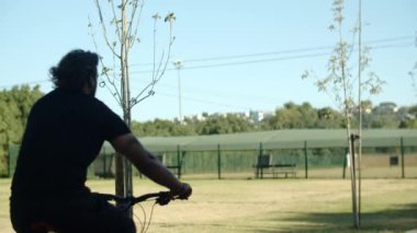 Özürlü bir adamın merdivenlerden bisikletle inerken uzun bir fotoğrafı.