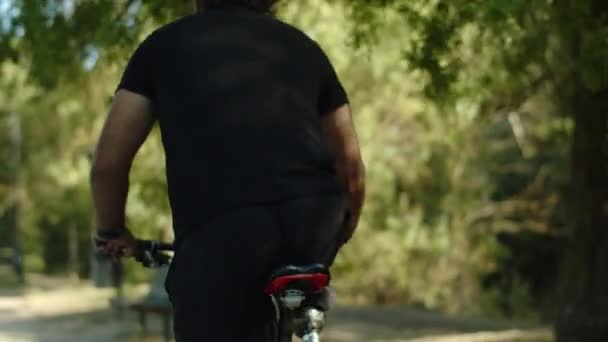 공원에서 장애인 자전거타기를 하는 사람의 뒷모습 — 비디오