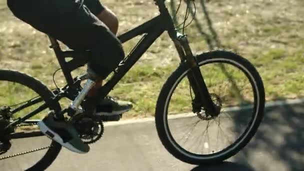 Vue latérale de l'homme méconnaissable avec vélo bionique jambe dans le parc — Video