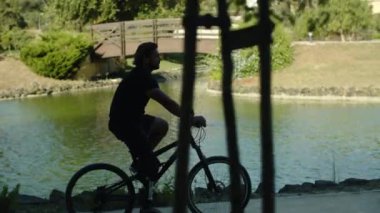 Parkta bisiklet süren ciddi engelli bir adamın el kamerası görüntüsü.