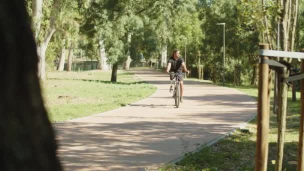사람의 긴 샷 생체 자전거를 타고 공원에서 길을 따라 자전거를 타고 사람 — 비디오