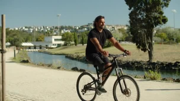 Pitkä laukaus keskittynyt mies proteesi jalka ratsastus pyörä puistossa — kuvapankkivideo