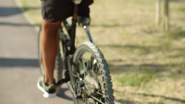 Primer plano del hombre con bionic pierna bicicleta de montar en el parque de verano — Vídeos de Stock