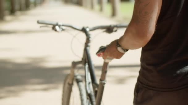 Close-up shot of mans hands holding seat of bike — Stock Video