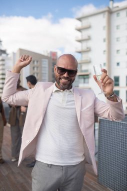 Partide şampanya bardağıyla keyifli sakallı adam.