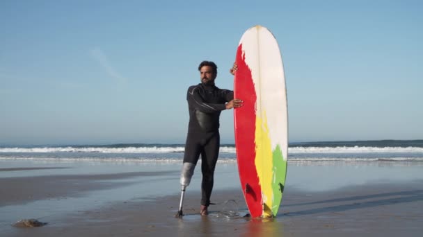 Lange kans van surfer met een handicap staan op oceaan kust — Stockvideo