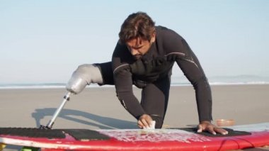 Yapay bacak ağdası sörf tahtasıyla sörfçünün statik görüntüsü 