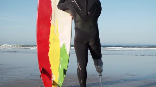 Colpo verticale di surfista con disabilità ammirando la bellezza di oceano — Video Stock