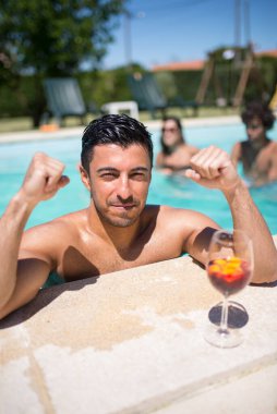 Atletik adam ve yüzme havuzunda parlak kokteyl.