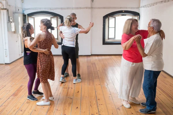 Senior Caucasian dancers smiling and dancing in pairs