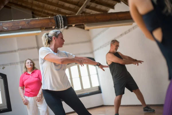 Kıdemli dansçılar kollarını uzatıyor.