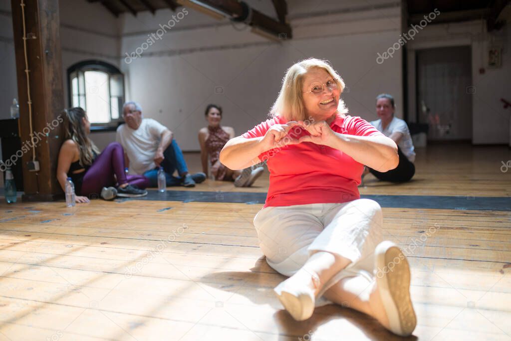 Happy female retiree showing heart with her hands