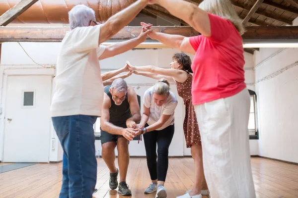 Çiftler için kollarıyla kemer yapan komik kıdemli dansçılar.