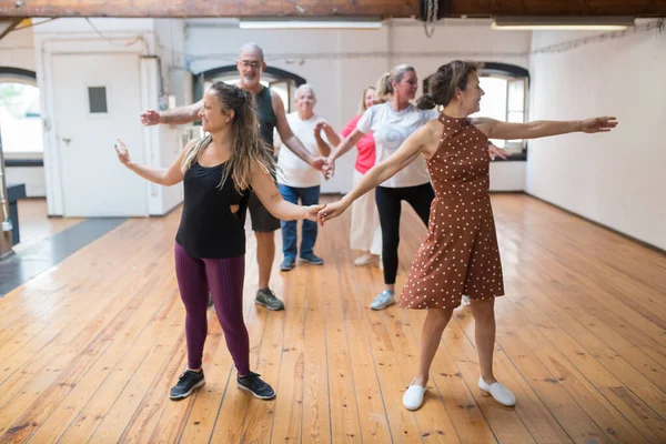 Mutlu genç Kafkasyalı eğitmen son sınıflara çift olarak dans etmeyi öğretiyor.