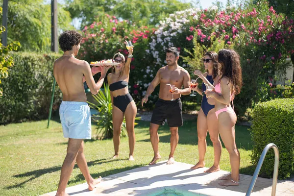 Pleased young friends at swimming pool party — Stock Photo, Image